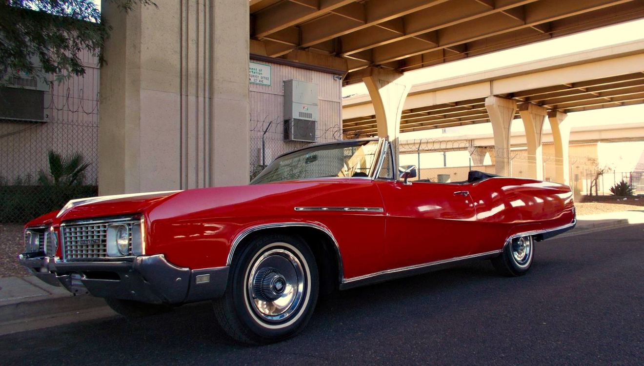 Red Buick convertible parked under a Phoenix freeway
