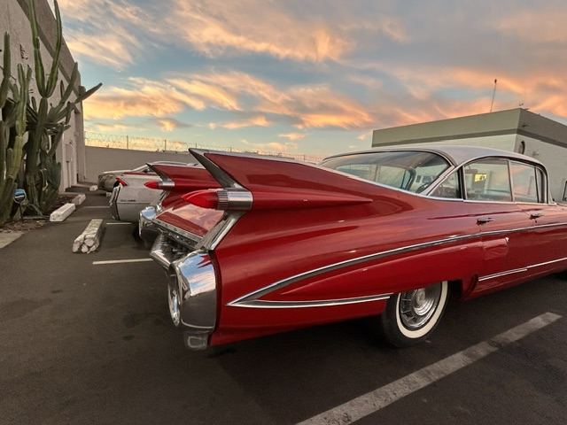 Red 1959 Cadillac fins at sunset outside the shop