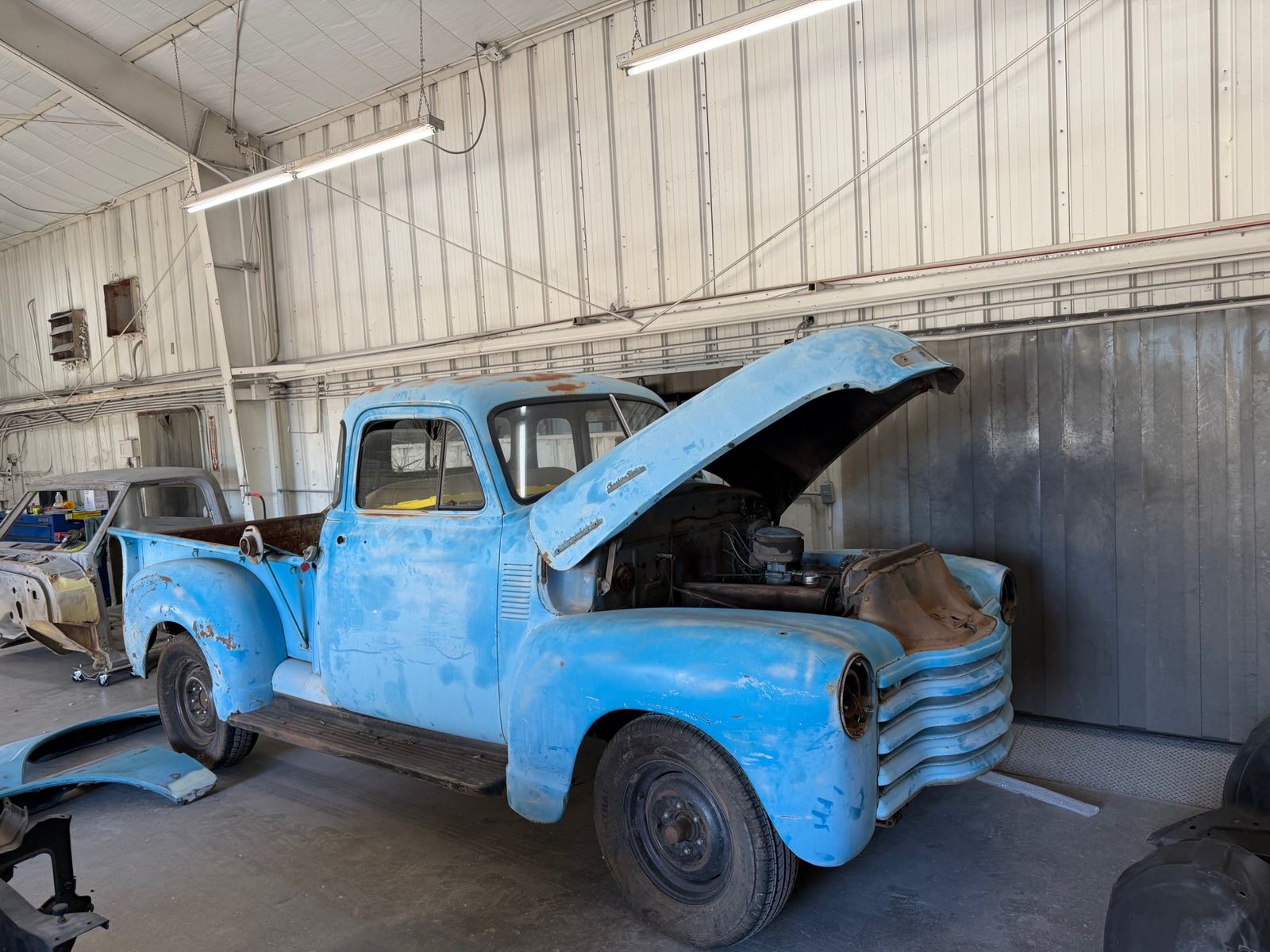 A rusty blue Chevrolet 3100 pickup waiting for bodywork