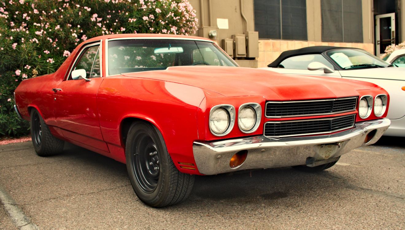 Red Chevrolet El Camino with black steel wheels