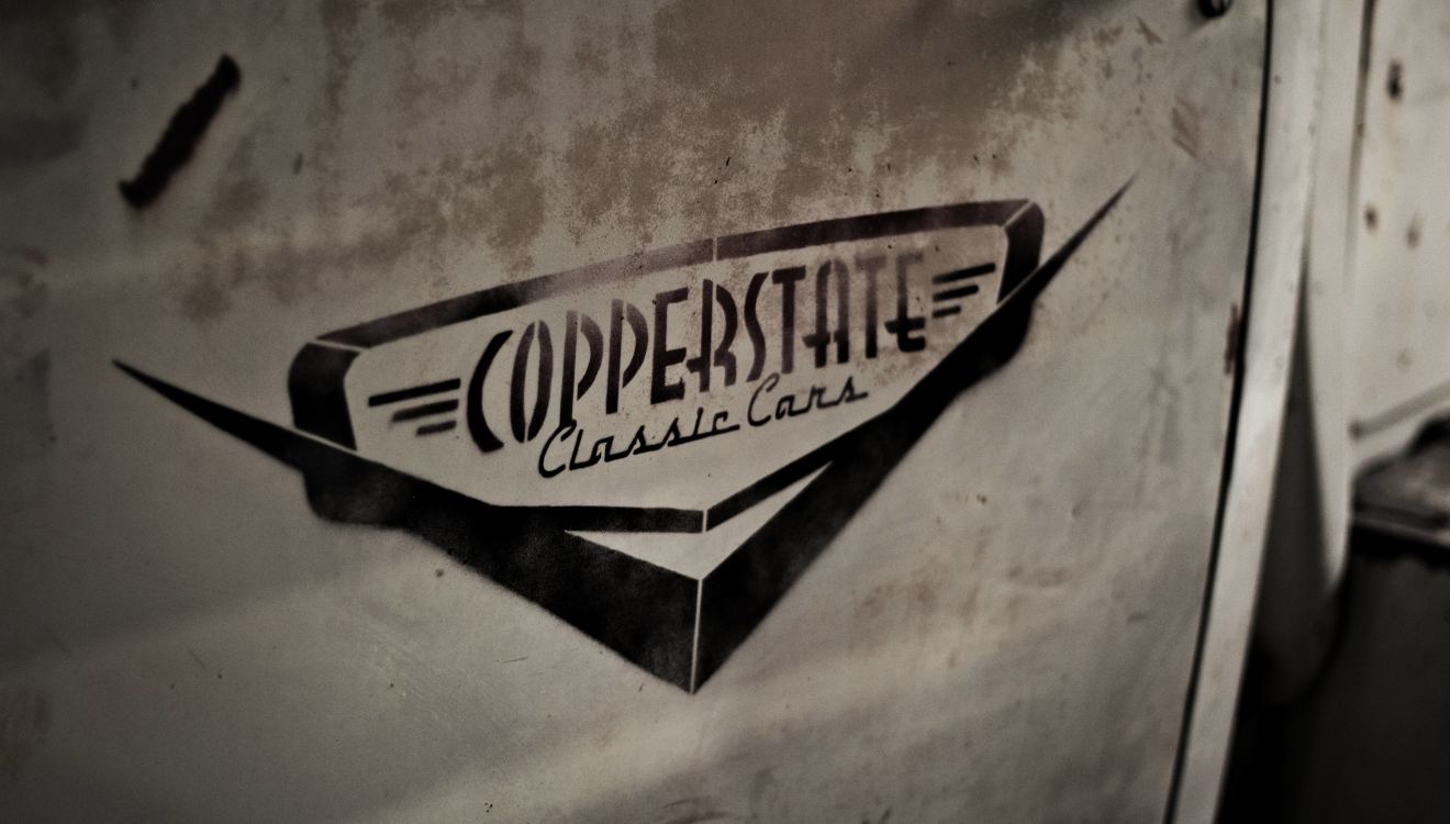 The Copperstate Classic Cars logo stenciled on a shop door