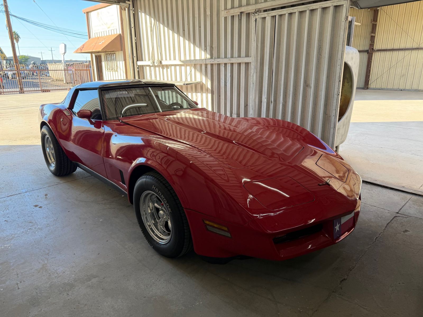 Red Chevrolet Corvette C3 at the body shop door
