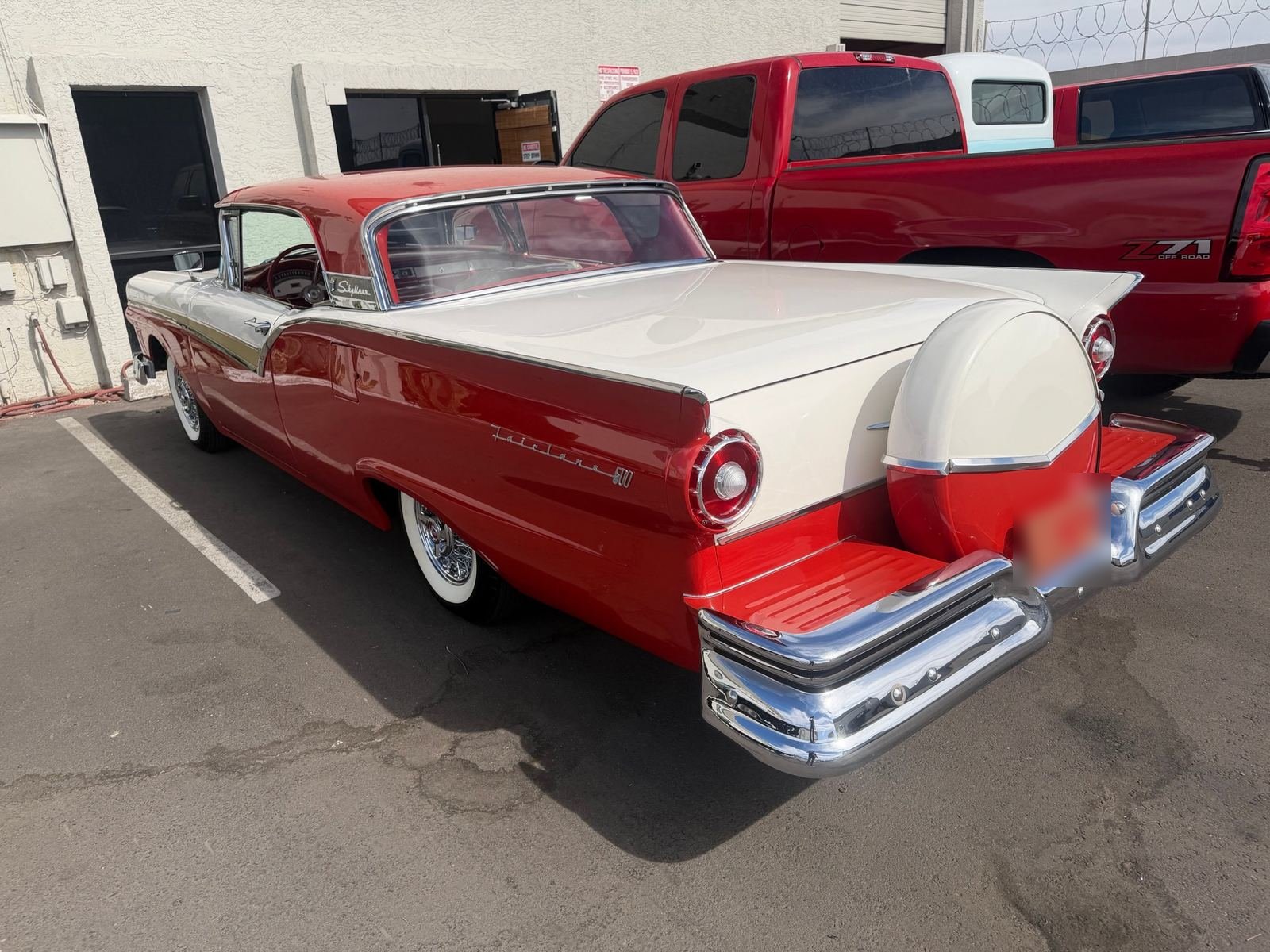 Red and white 1957 Ford Fairlane 500 Skyliner with a continental kit
